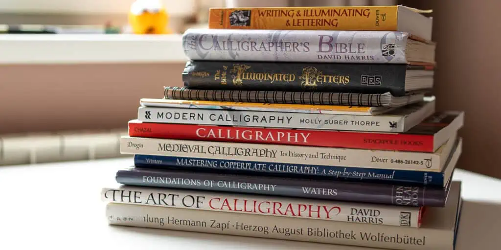 Best calligraphy books for beginners stacked on top of each other. 