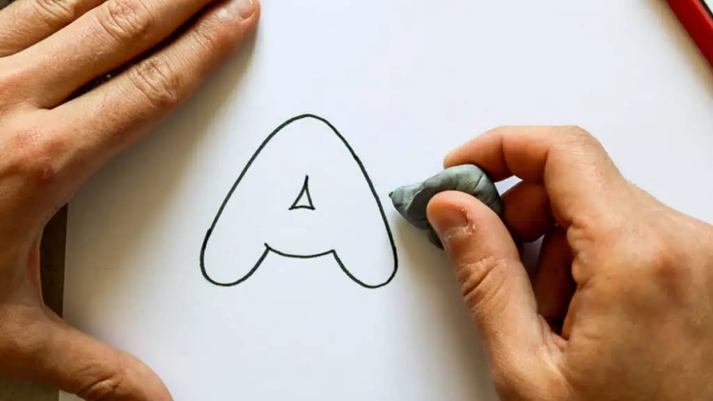 Erasing the pencil mark after the letter is outlined