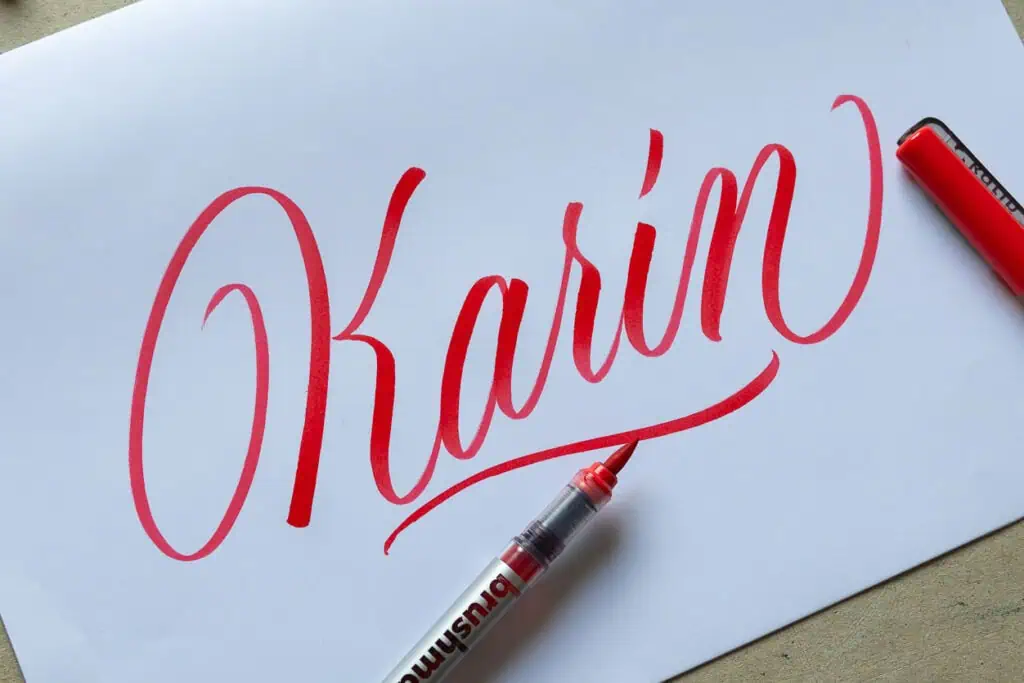 Red flowy brush calligraphy with Karin brush pen.