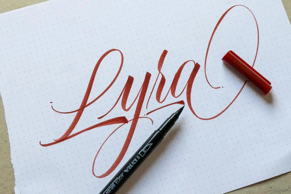 Maroon brush calligraphy on paper with Lyra brush pen